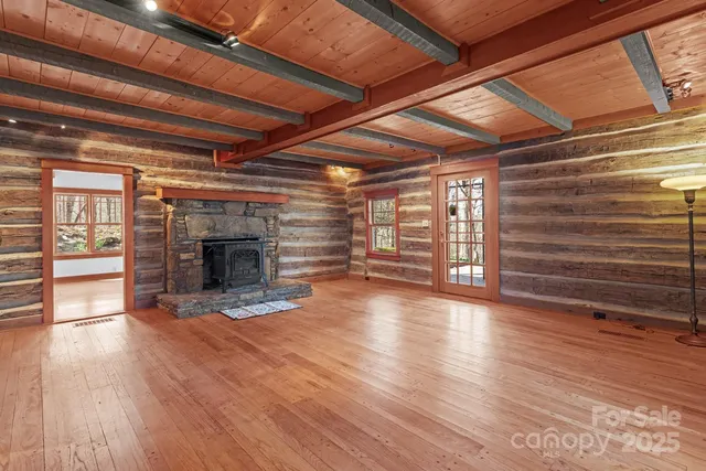 a view of empty room with wooden floor and fireplace