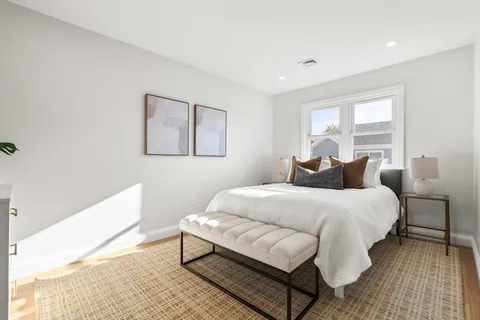 a bedroom with a bed lamp and a window