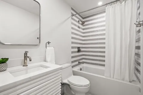 a bathroom with a sink a toilet a mirror and shower