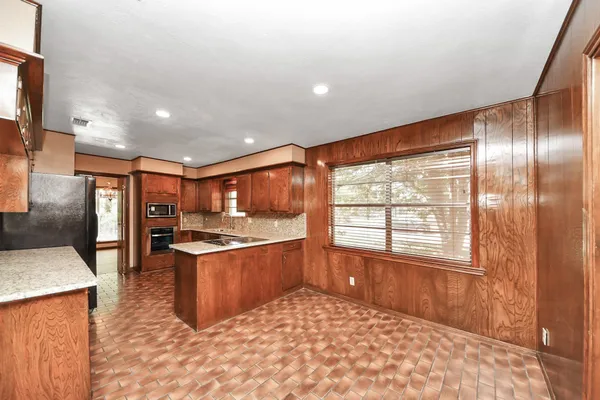 a large kitchen with stainless steel appliances granite countertop a sink stove and refrigerator