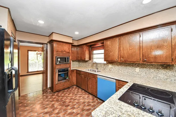 a kitchen with stainless steel appliances granite countertop sink stove and refrigerator
