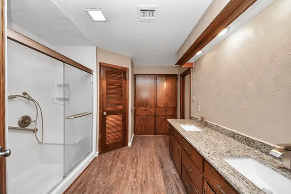 a bathroom with a granite countertop sink a mirror and shower