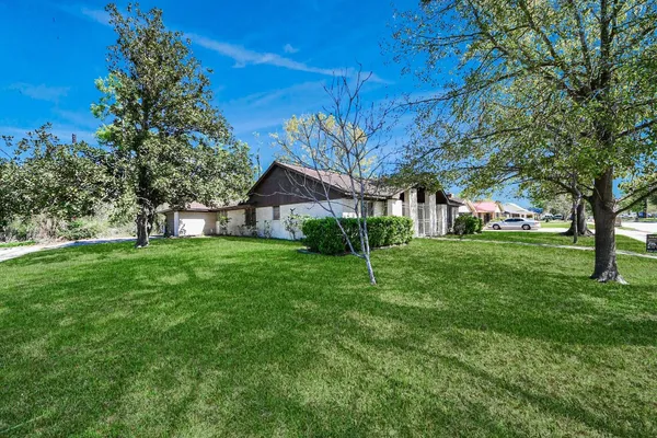 a view of an house with backyard and trees