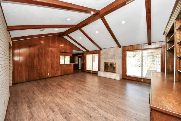 a view of an empty room with wooden floor and staircase