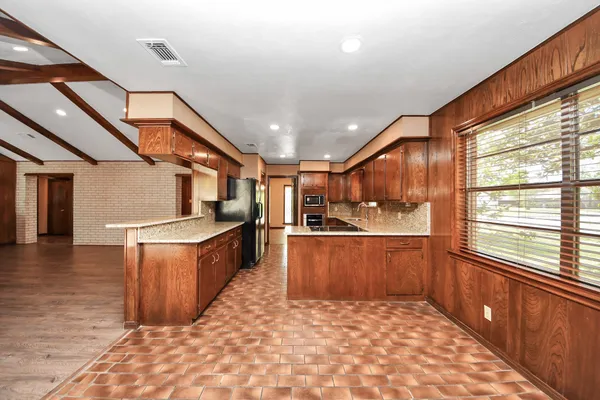 a large kitchen with stainless steel appliances kitchen island granite countertop a large counter top and swing