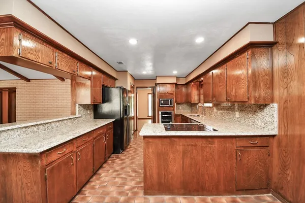a kitchen with stainless steel appliances kitchen island granite countertop a sink and cabinets