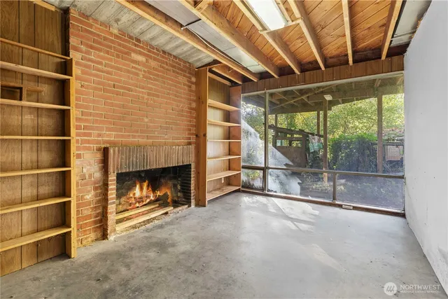 a view of an empty room with a fireplace and a window