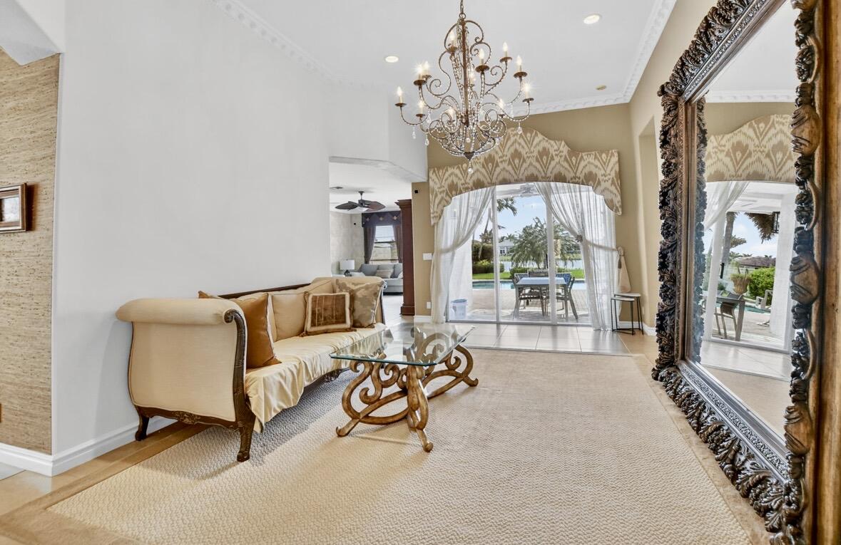 7879 Monarch Court Delray Beach, FL 33446 - Photo 15 of 74 a living room with furniture a chandelier and a large window