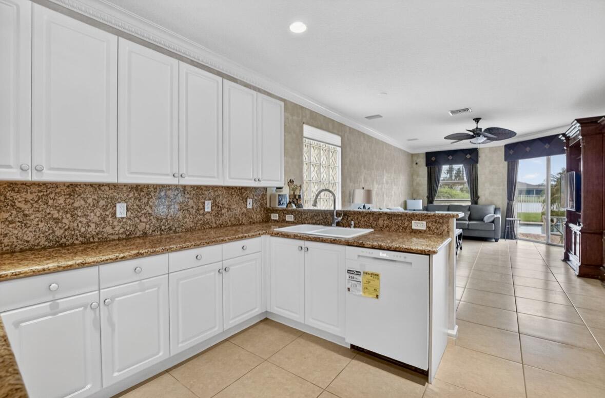 7879 Monarch Court Delray Beach, FL 33446 - Photo 26 of 74 a kitchen with stainless steel appliances granite countertop a sink and cabinets