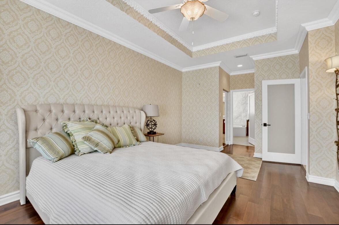 7879 Monarch Court Delray Beach, FL 33446 - Photo 32 of 74 a bedroom with a large bed and a chandelier