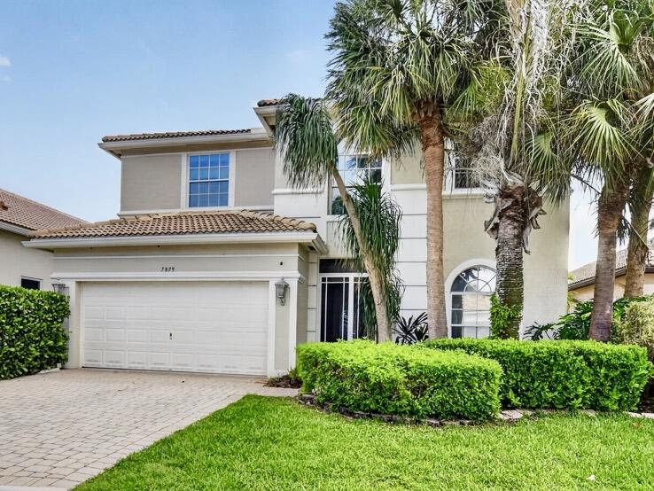 7879 Monarch Court Delray Beach, FL 33446 - Photo 6 of 74 a front view of a house with a garden and palm trees