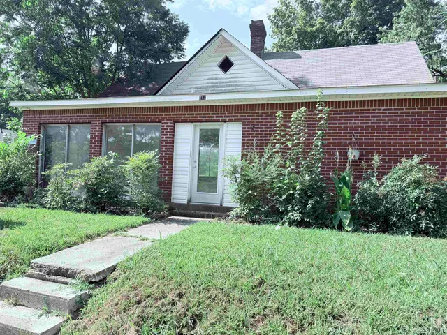 a view of a house with a yard and potted plants