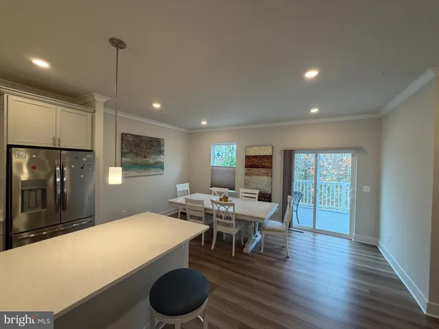 a kitchen with a table chairs refrigerator and microwave