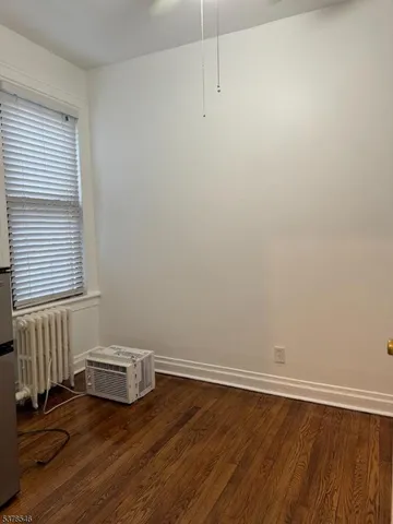 a view of a room with wooden floor and window