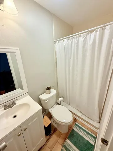 a bathroom with a sink a toilet and shower curtain
