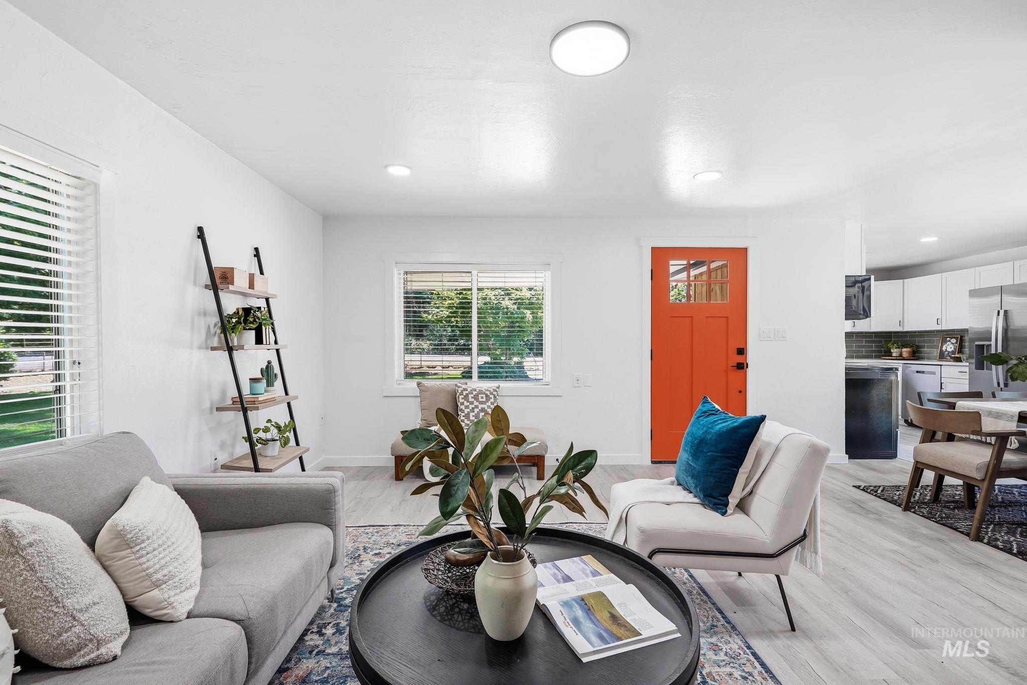 2152 Artesian Road Eagle, ID 83616 - Photo 8 of 50 Bright living space featuring light-toned wood-finish flooring, recessed lighting, and an orange entry door with clear glass panels