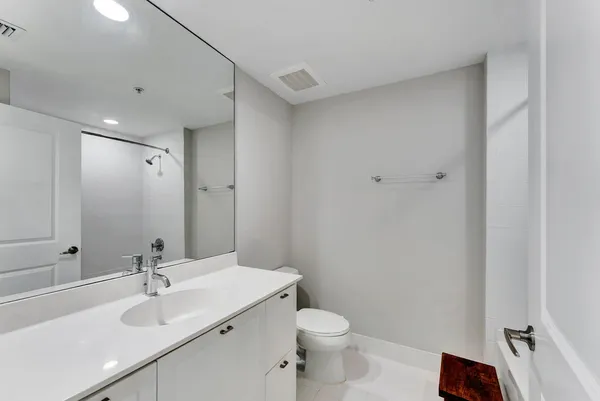 a bathroom with a sink toilet and a mirror