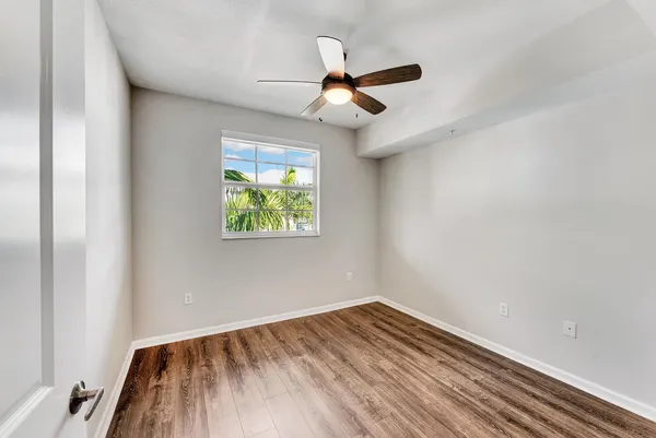a view of empty room with wooden floor