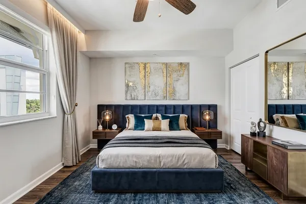 a bedroom with a bed a couch and a window with outer view
