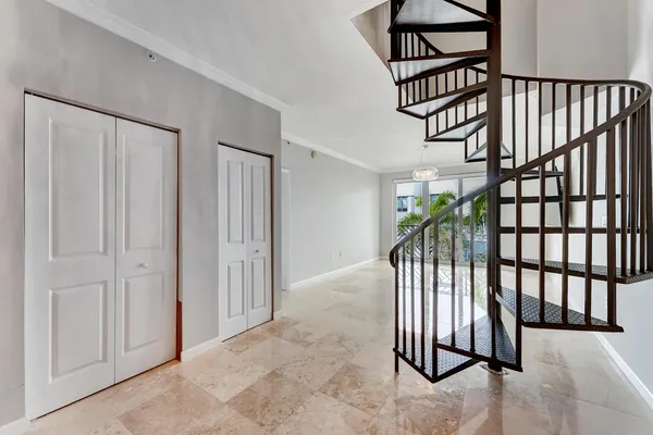 a view of staircase with railing and a chandelier