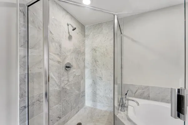 a bathroom with a tub a sink and mirror