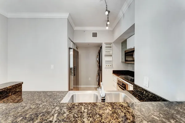 a kitchen with stainless steel appliances granite countertop a sink and a stove top oven
