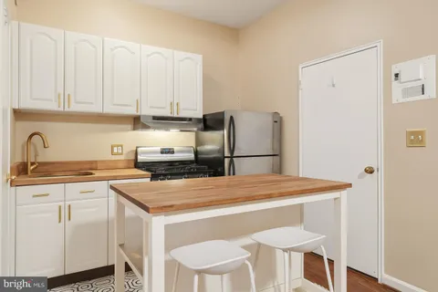 a kitchen with a white cabinets and refrigerator