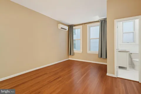an empty room with wooden floor and a window