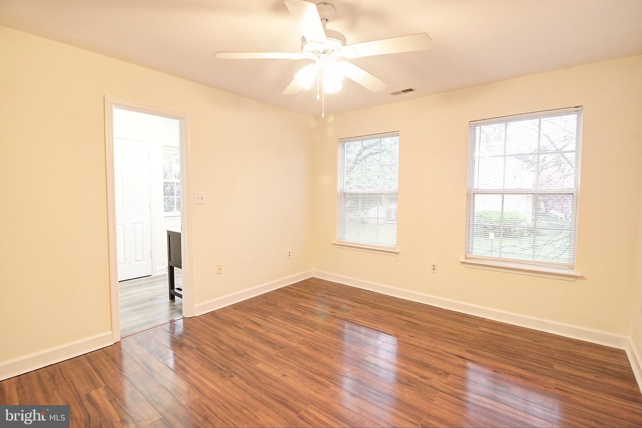 9261 Ridgefield Circle Frederick, MD 21701 - Photo 12 of 27 an empty room with wooden floor chandelier fan and windows