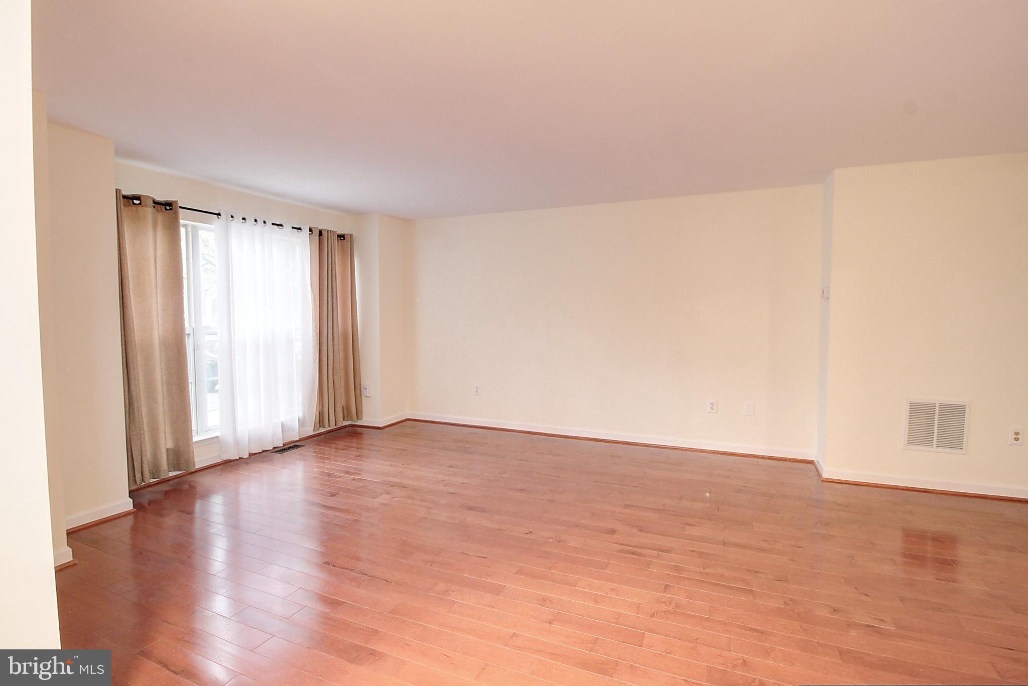 9261 Ridgefield Circle Frederick, MD 21701 - Photo 4 of 27 a view of an empty room with wooden floor and a window