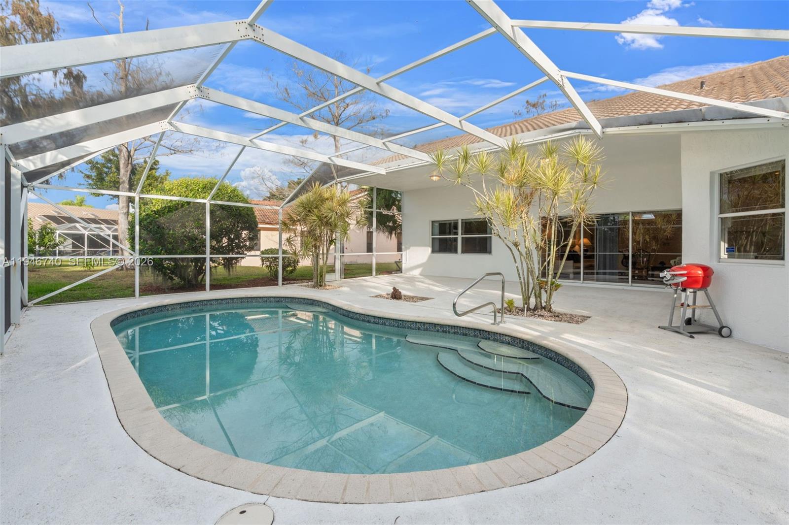 7901 Northwest 86th Terrace Tamarac, FL 33321 - Photo 32 of 42 a view of a swimming pool with a patio