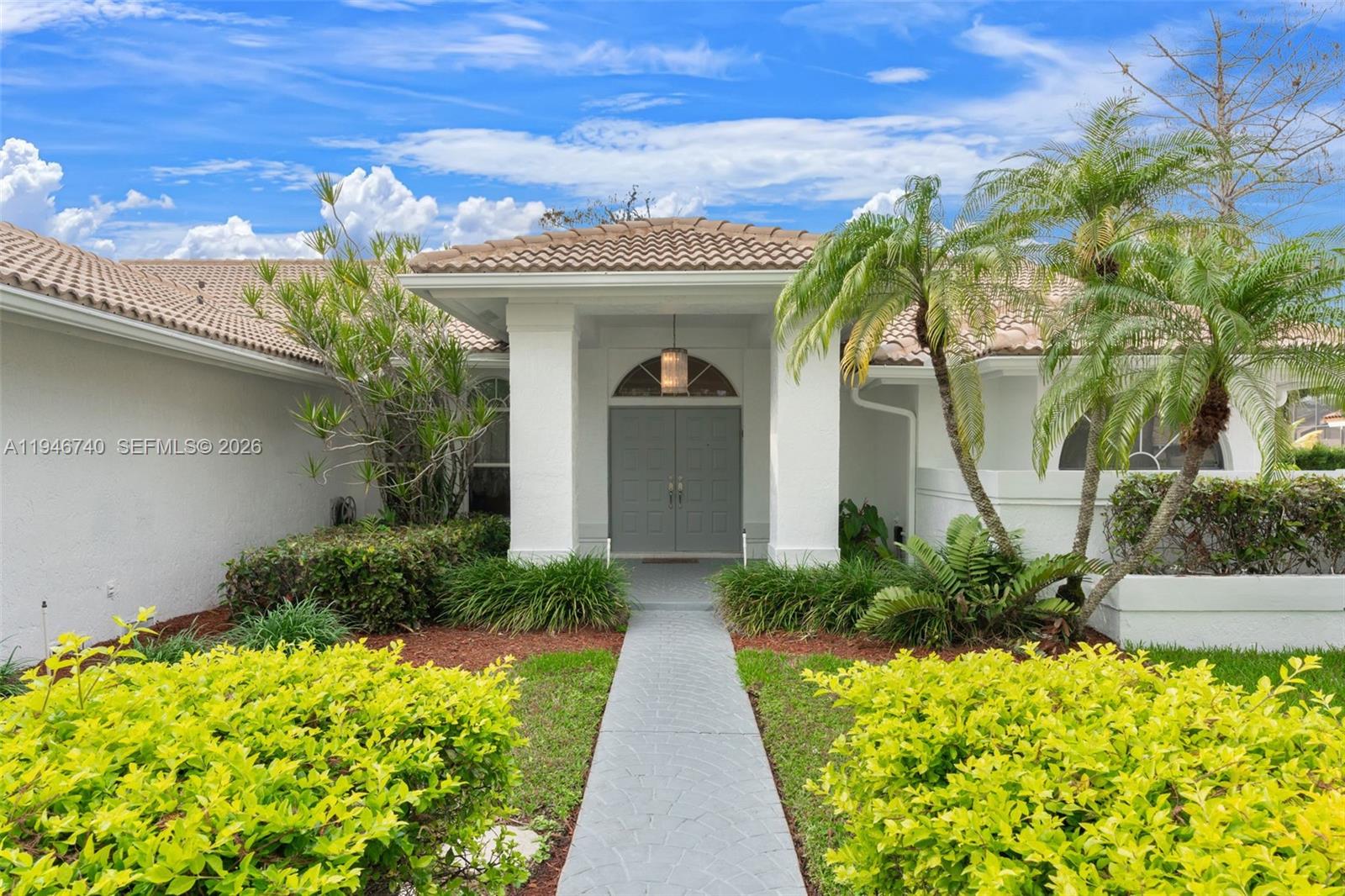 7901 Northwest 86th Terrace Tamarac, FL 33321 - Photo 8 of 42 a front view of a house with a garden