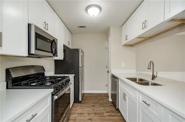 a kitchen with stainless steel appliances granite countertop a sink stove and refrigerator