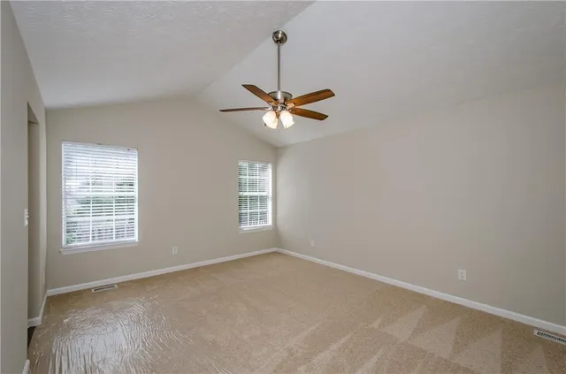 an empty room with window and a ceiling fan