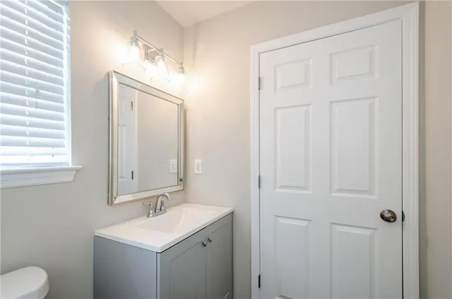 a bathroom with a toilet sink and mirror