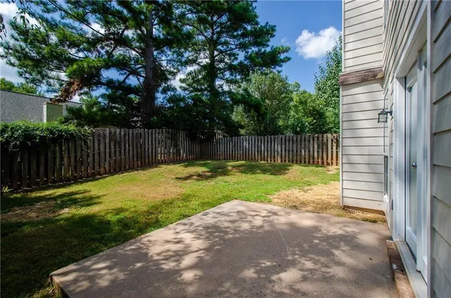 a view of a backyard with a small cabin and wooden fence