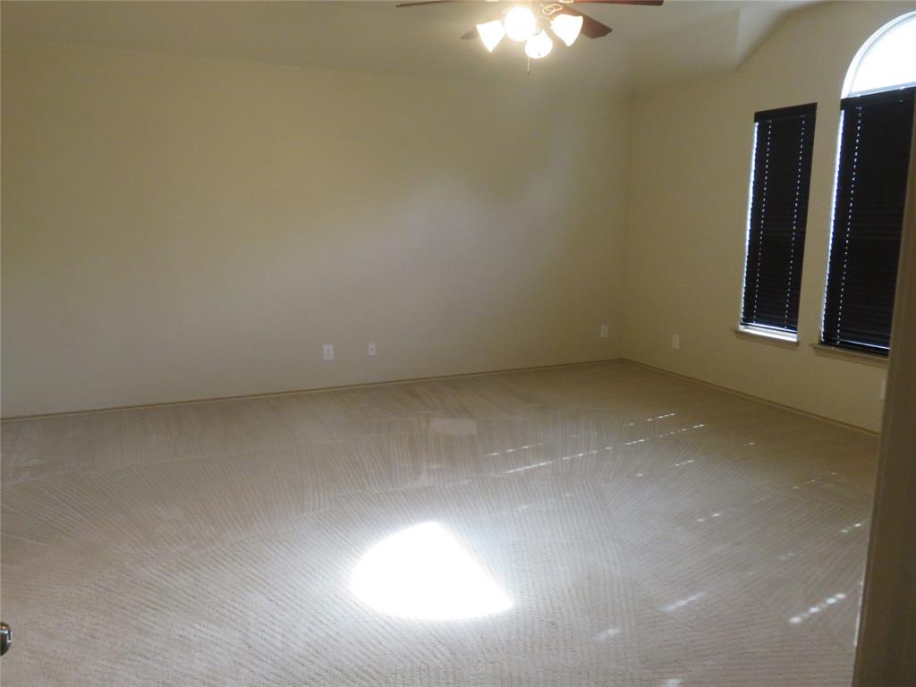 1122 Walter Stephenson Road Midlothian, TX 76065 - Photo 16 of 26 Spacious room featuring neutral carpet flooring, light-colored walls, and a ceiling fan with integrated lighting