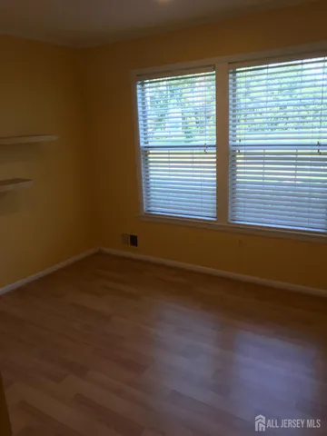 a view of a room with wooden floor and a window