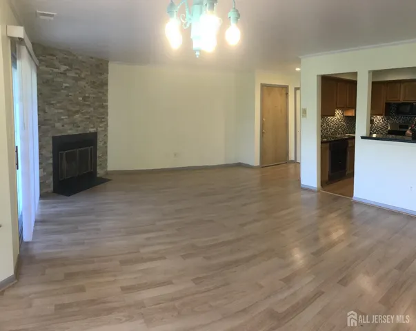 a view of empty room with kitchen and window