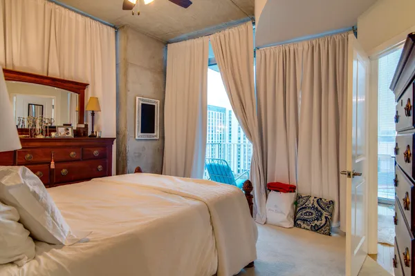 a bedroom with a bed and a large window