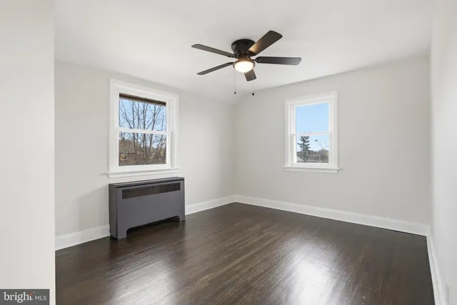 a view of workspace with wooden floor fan and windows