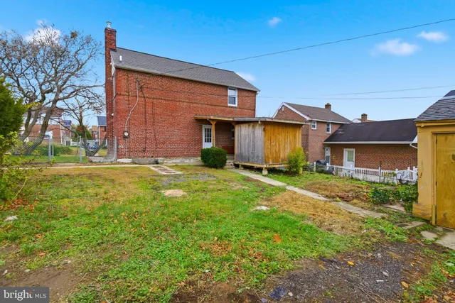 a view of a house with a big yard and large tree