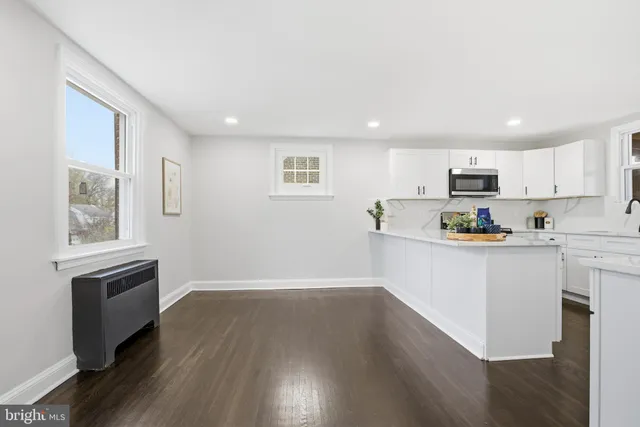 a kitchen with granite countertop a refrigerator and a stove top oven