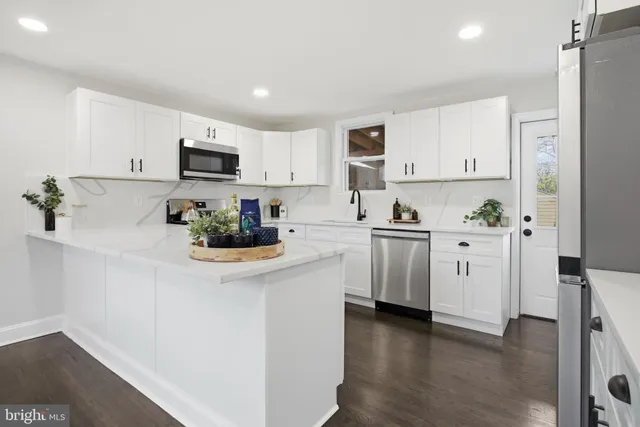 a kitchen with white cabinets and stainless steel appliances