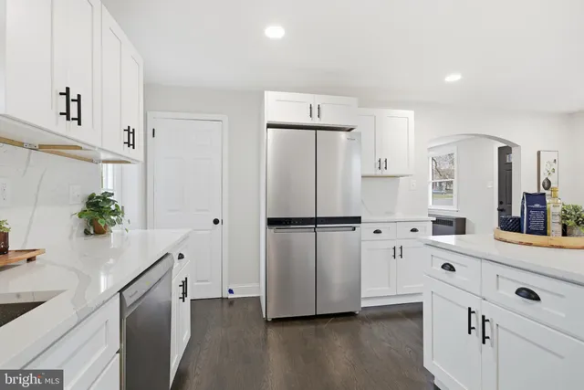 a kitchen with white cabinets and white appliances