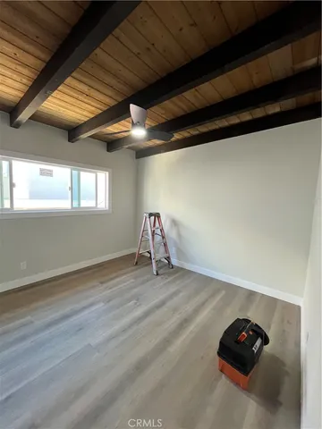 a view of a room with wooden floor and ceiling fan
