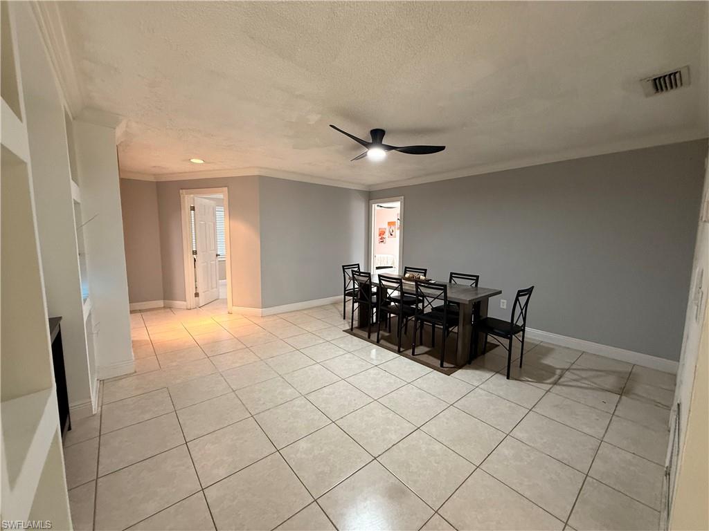 3536 Bolero Way Naples, FL 34105 - Photo 18 of 25 Dining space with ornamental molding, a textured ceiling, light tile patterned flooring, and a ceiling fan