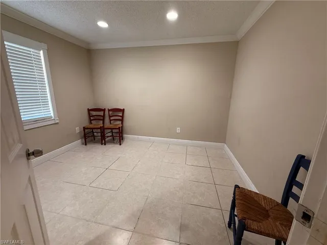 a bedroom with a bed a flat screen tv and next to a window