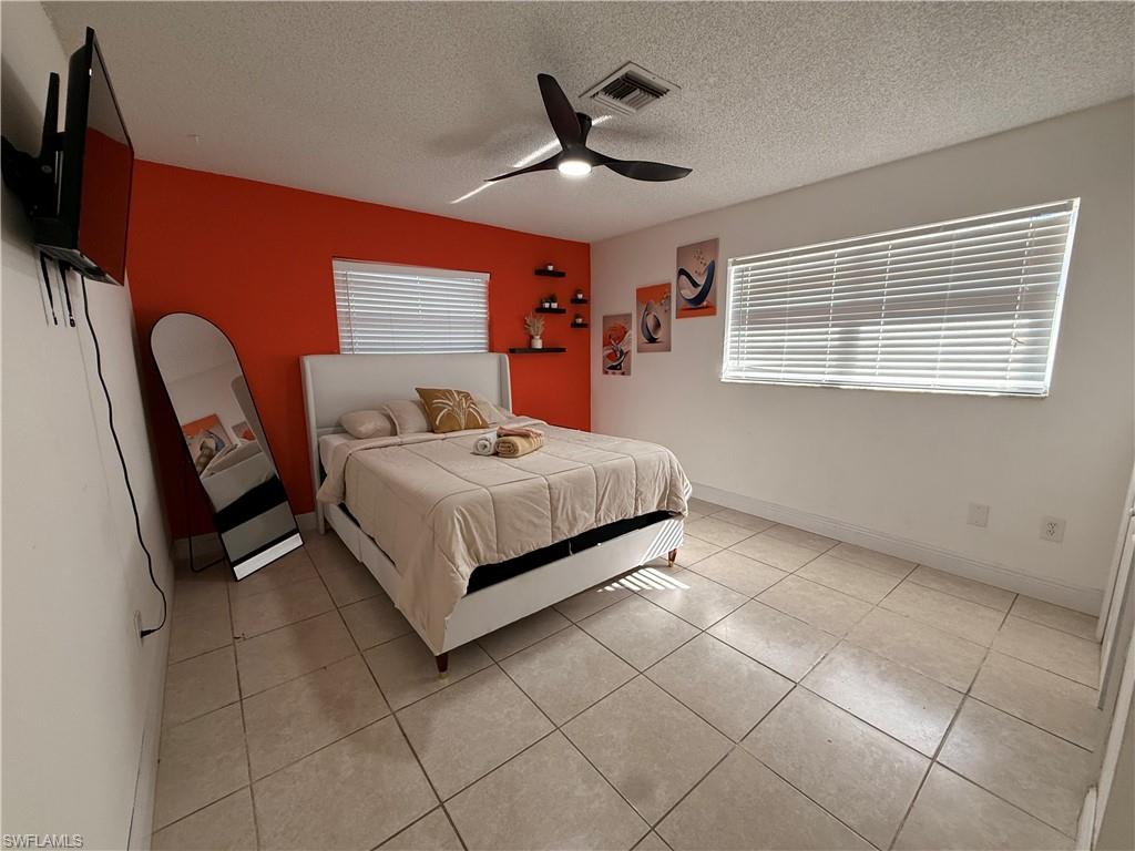 3536 Bolero Way Naples, FL 34105 - Photo 21 of 25 Bedroom with ceiling fan, a textured ceiling, and light tile patterned floors
