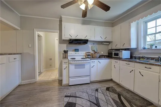 a kitchen with granite countertop white cabinets and white appliances